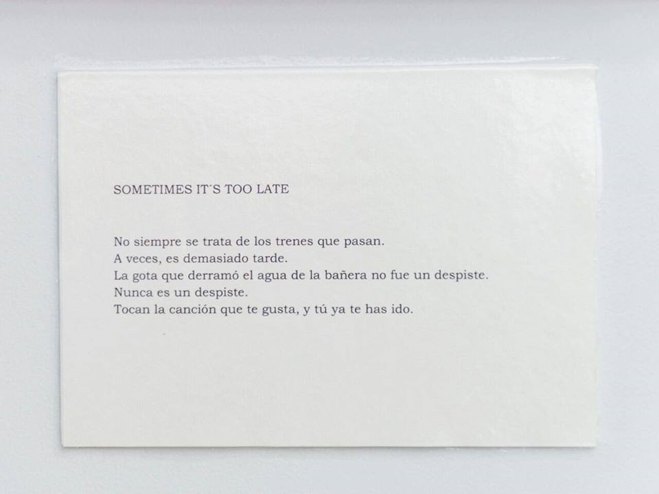 Tarjeta mecanografiada con el poema «Sometimes it’s too late»: No siempre se trata de los trenes que pasan. A veces, es demasiado tarde. La gota que derramó el agua de la bañera no fue un despiste. Nunca es un despiste. Tocan la canción que te gusta, y tú ya te has ido.